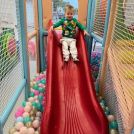 A child about to go down the slide at our soft play in Addestone